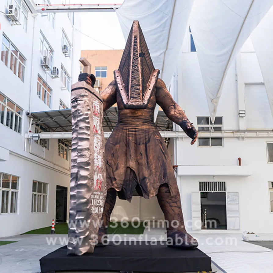 7m high Silent Hill Pyramid Head inflatable standing on black base in factory yard