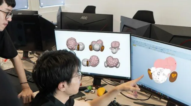 360 Inflatable design team reviewing 3D model of custom IP inflatable on dual monitors