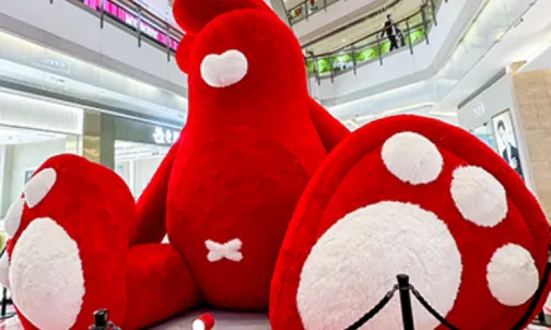 Giant plush cartoon character inflatable installation at shopping mall