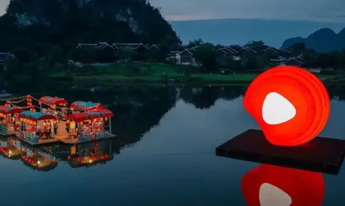 Floating lantern inflatable installation on lake at dusk